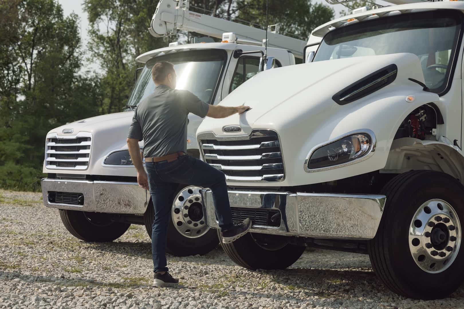 Freightliner M2 106 Plus commercial truck undergoing inspection by a technician
