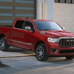 A red RAM 1500 parked in a house's driveway