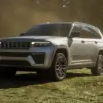 A silver Jeep Grand Cherokee on a cut field of grass