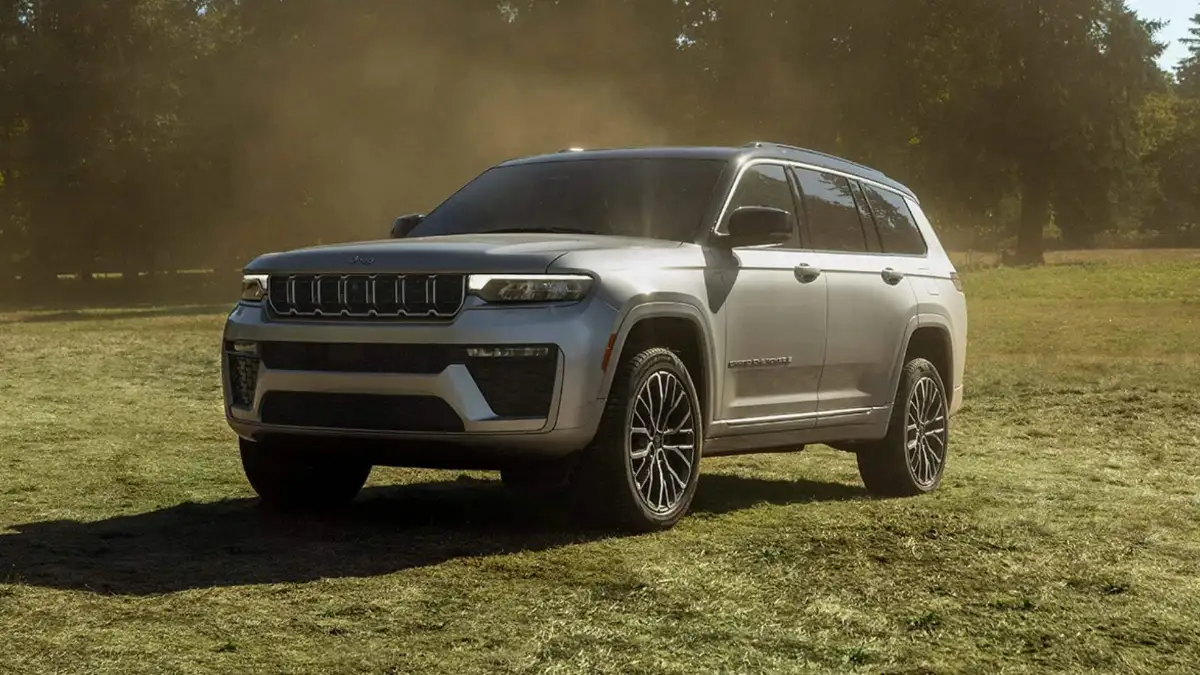 A silver Jeep Grand Cherokee on a cut field of grass