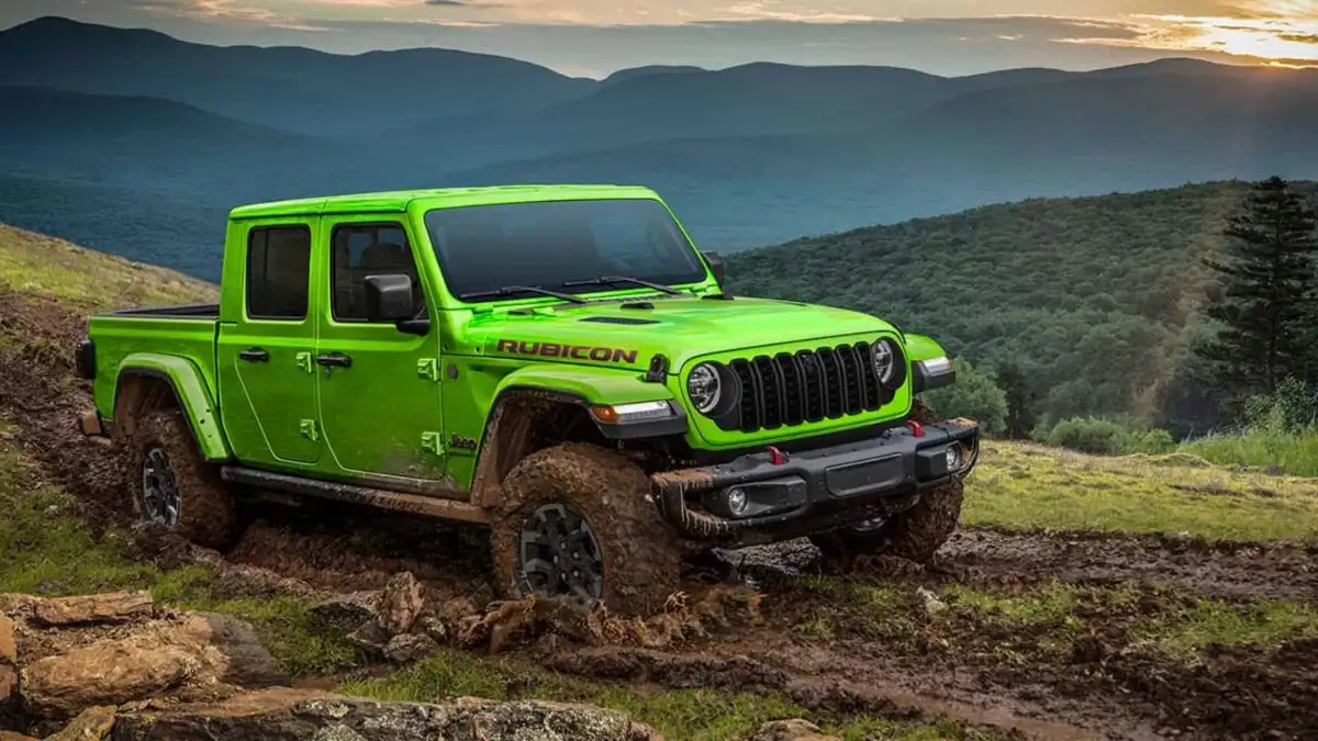 A lime Jeep Gladiator driving over mud on a hill