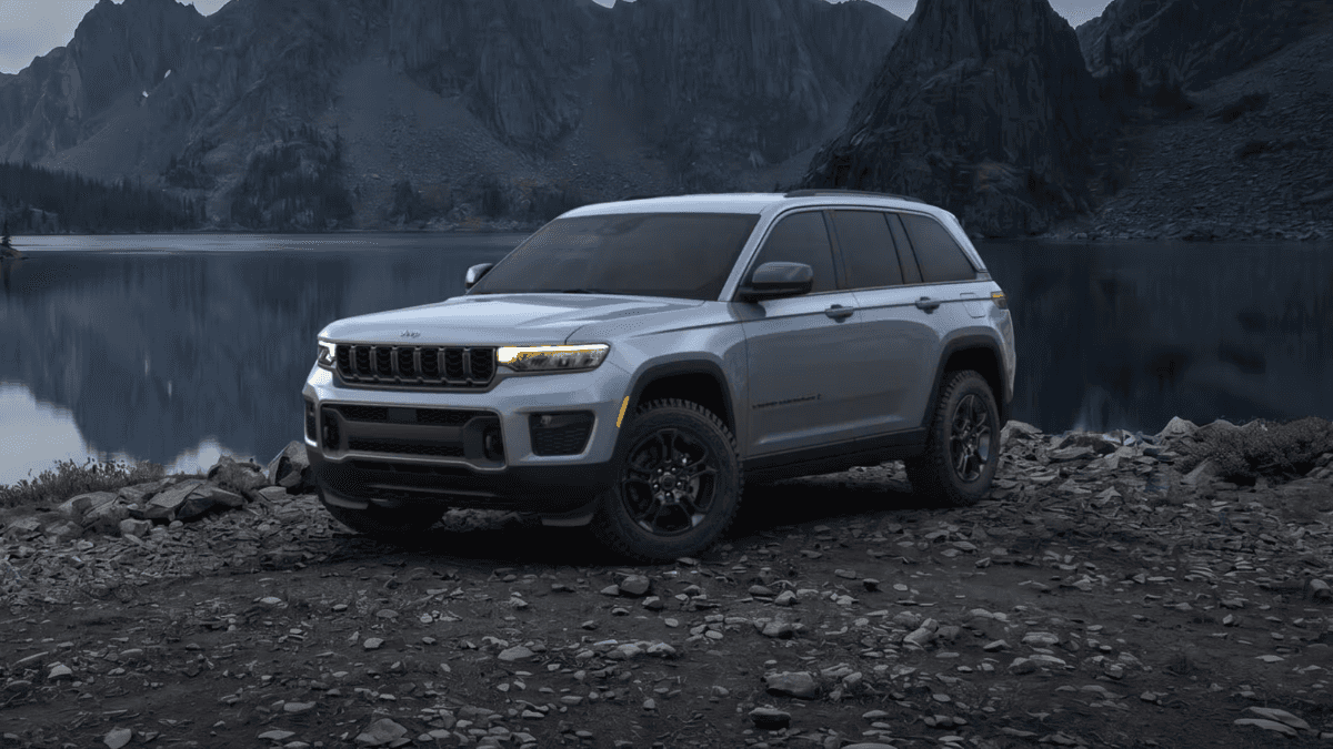 A silver Jeep Grand Cherokee parked on a lake bed at night