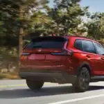 A rear view of red Honda CR-V driving down the road