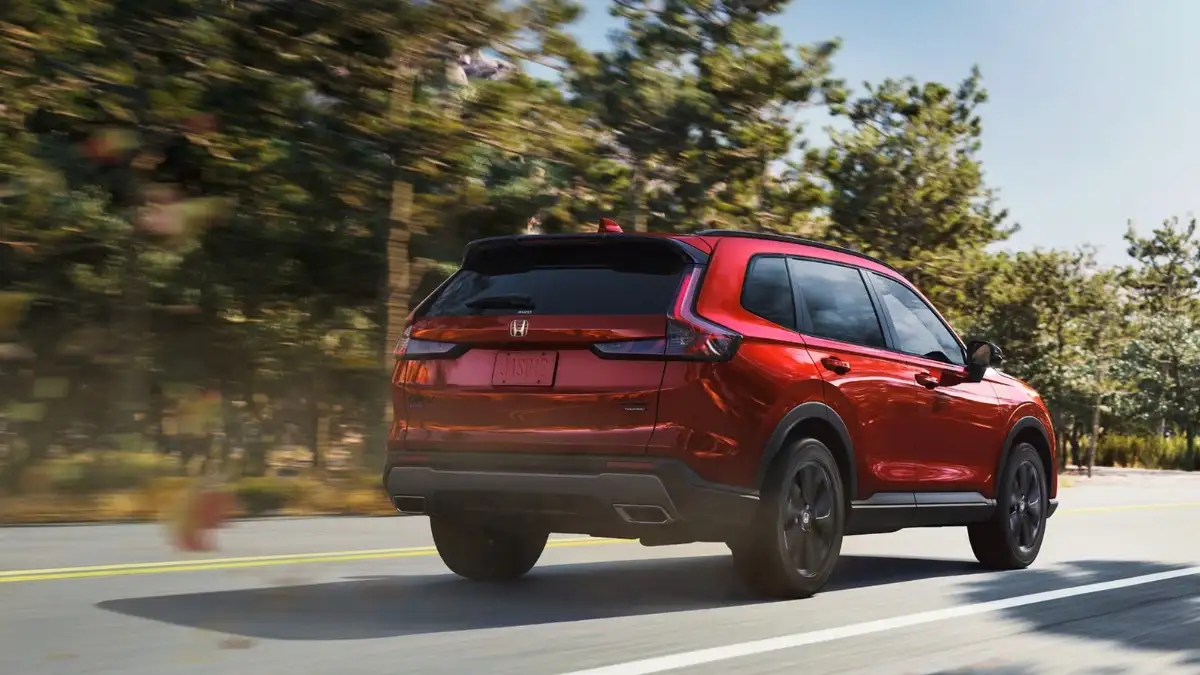A rear view of red Honda CR-V driving down the road