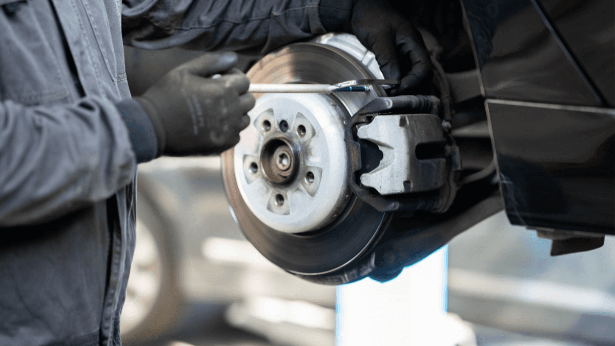 A technician working on a vehicle's brake discs