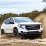 White 2024 GMC Terrain AT4 driving to a GMC dealer