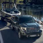 Grey 2021 GMC Sierra1500 towing a boat past a lake