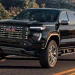 Black 2026 GMC Canyon Denali driving on a highway
