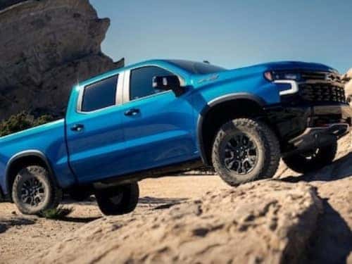 2024 Chevrolet Silverado 1500 driving up a rocky hill