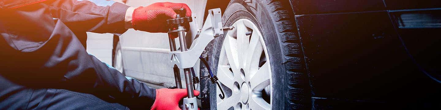 Close up view of a service tech doing a wheel alignment