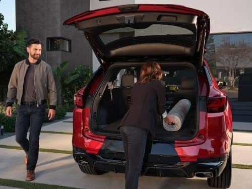 2025 Chevrolet Blazer view of woman loading a rug into the back of the vehicle