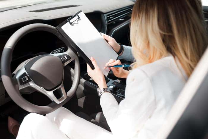 Woman signs a lease deal for her new car