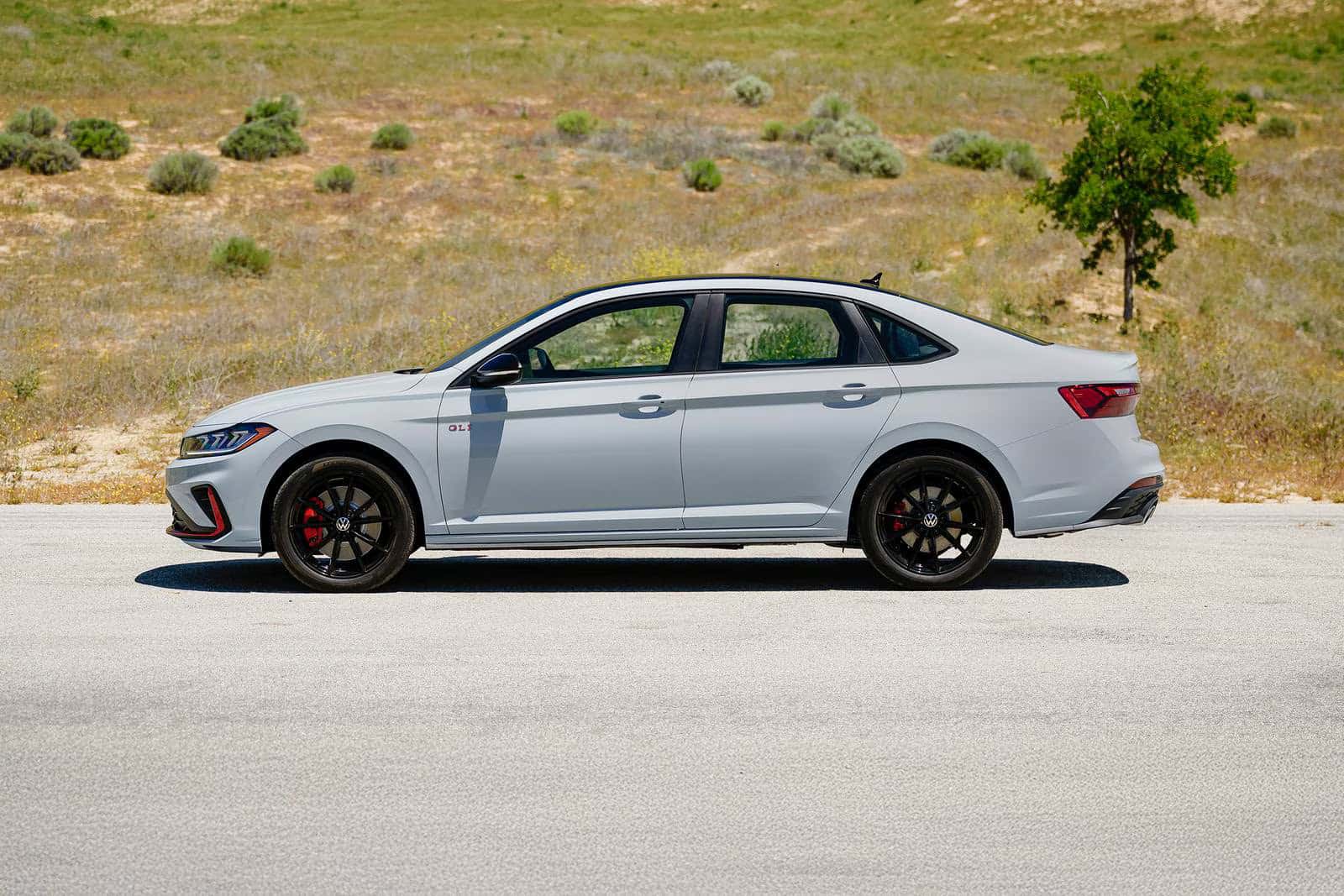 a new look at the 2026 Volkswagen Jetta GLI driving next to a hill