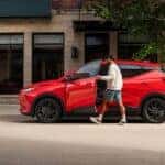 A man entering his red 2027 Chevy Bolt