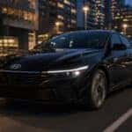 2026 Hyundai Elantra in Abyss Black Pearl driving through urban cityscape at night — Webb Hyundai Merrillville, Merrillville, IN