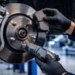 Hyundai brake service at Webb Hyundai Merrillville — technician inspecting brake pads and rotor in the service center