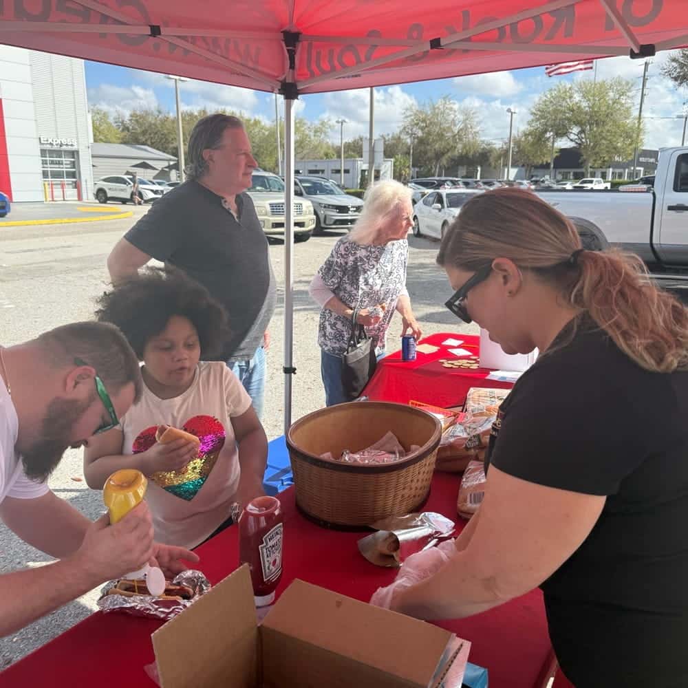 Event Attendees Dressing Hotdogs in Hits 106 Radio Tent