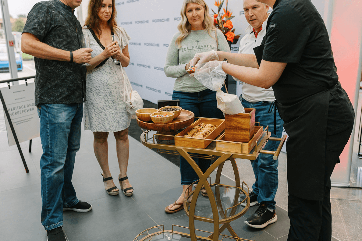 Guests enjoying freshly prepared cannolis at Porsche Des Moines grand opening event