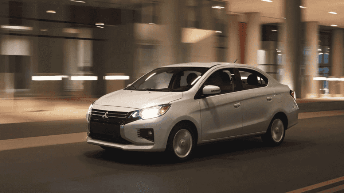 2024 Mitsubishi Mirage G4 exterior driving at night showing illuminated headlights and compact sedan profile