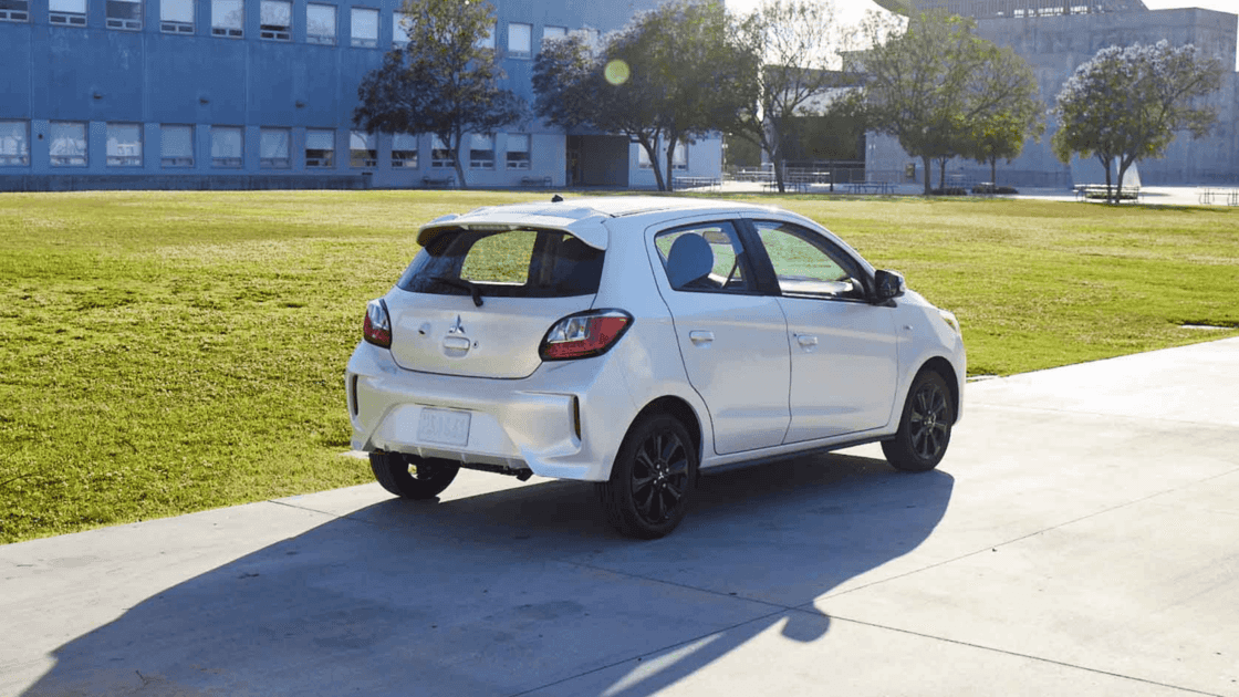2024 Mitsubishi Mirage rear three quarter exterior in white highlighting hatchback design, taillights, and black alloy wheels