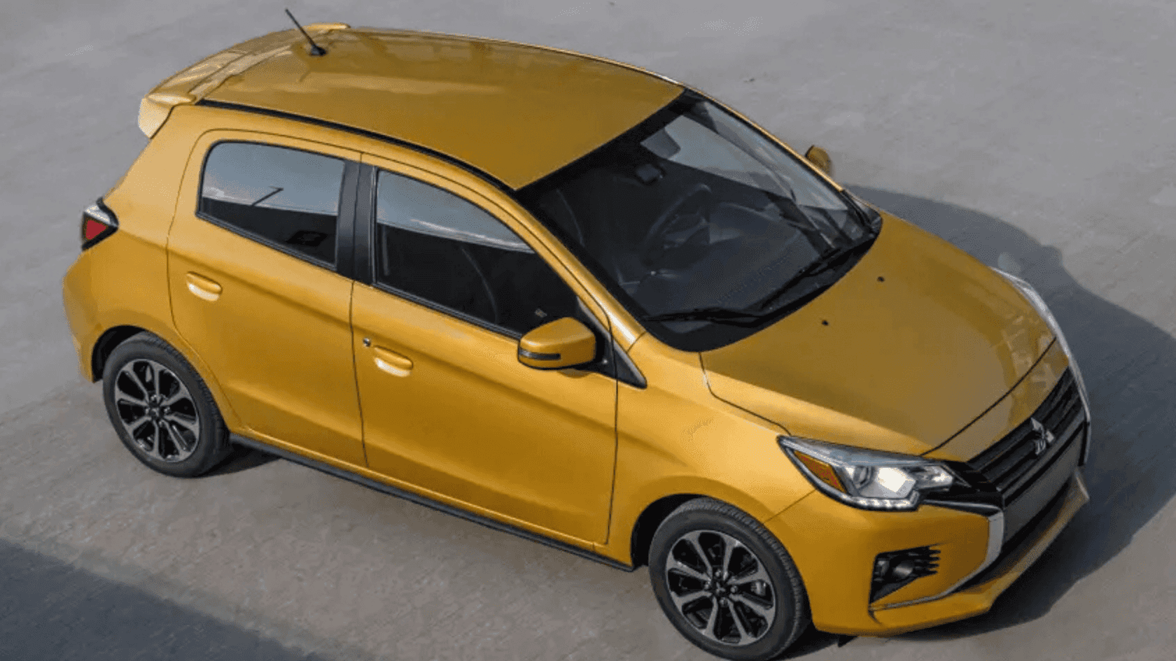 2024 Mitsubishi Mirage yellow hatchback photographed from elevated angle on concrete surface