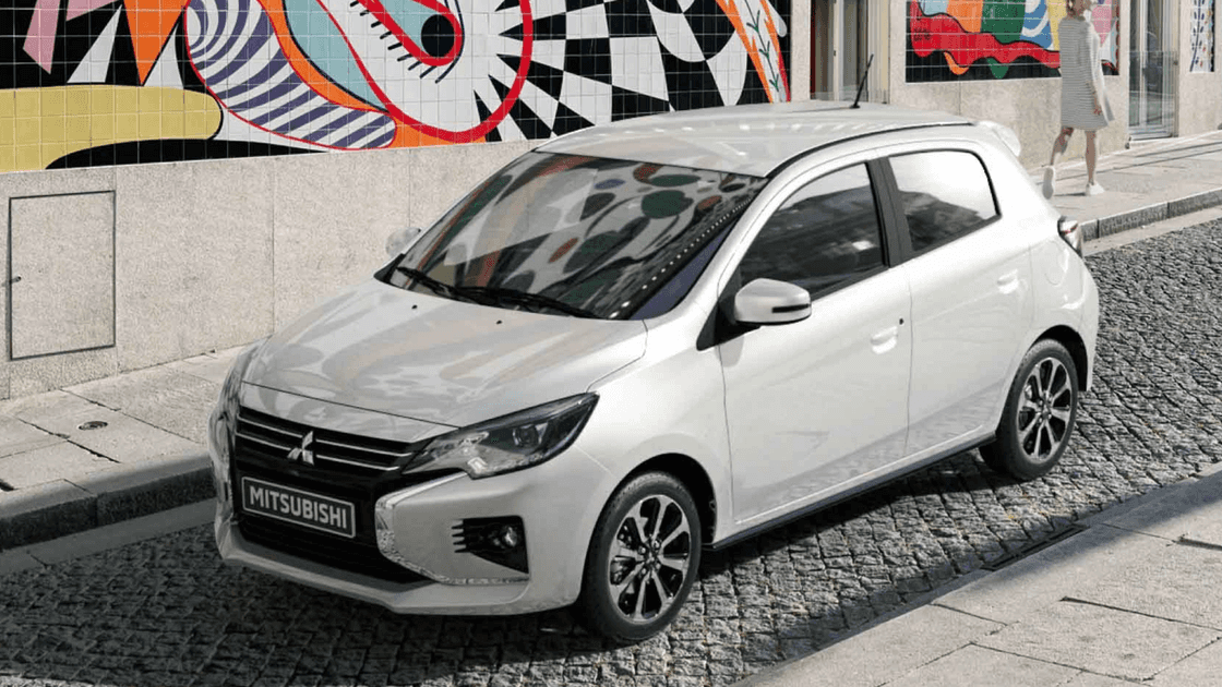 2024 Mitsubishi Mirage hatchback parked on cobblestone street showing front fascia, alloy wheels, and modern city styling