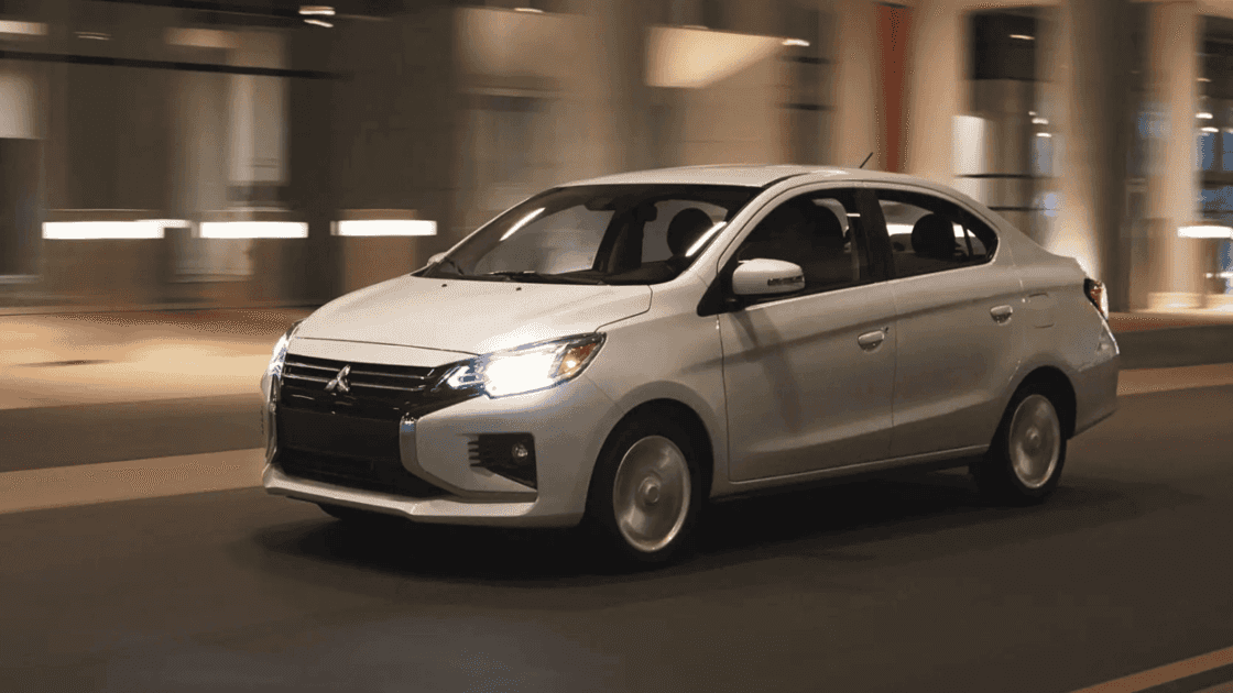 2024 Mitsubishi Mirage G4 exterior driving at night with headlights on highlighting compact sedan profile