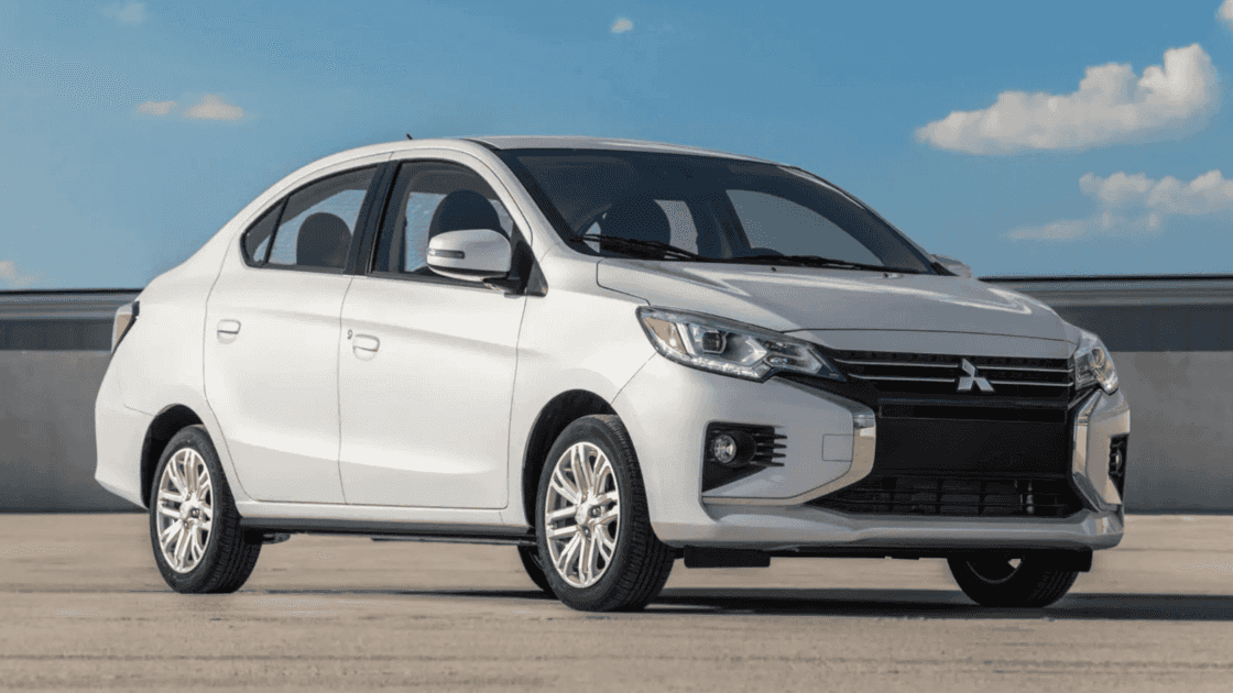 2024 Mitsubishi Mirage sedan, parked in a clear, open area with a bright blue sky overhead.
