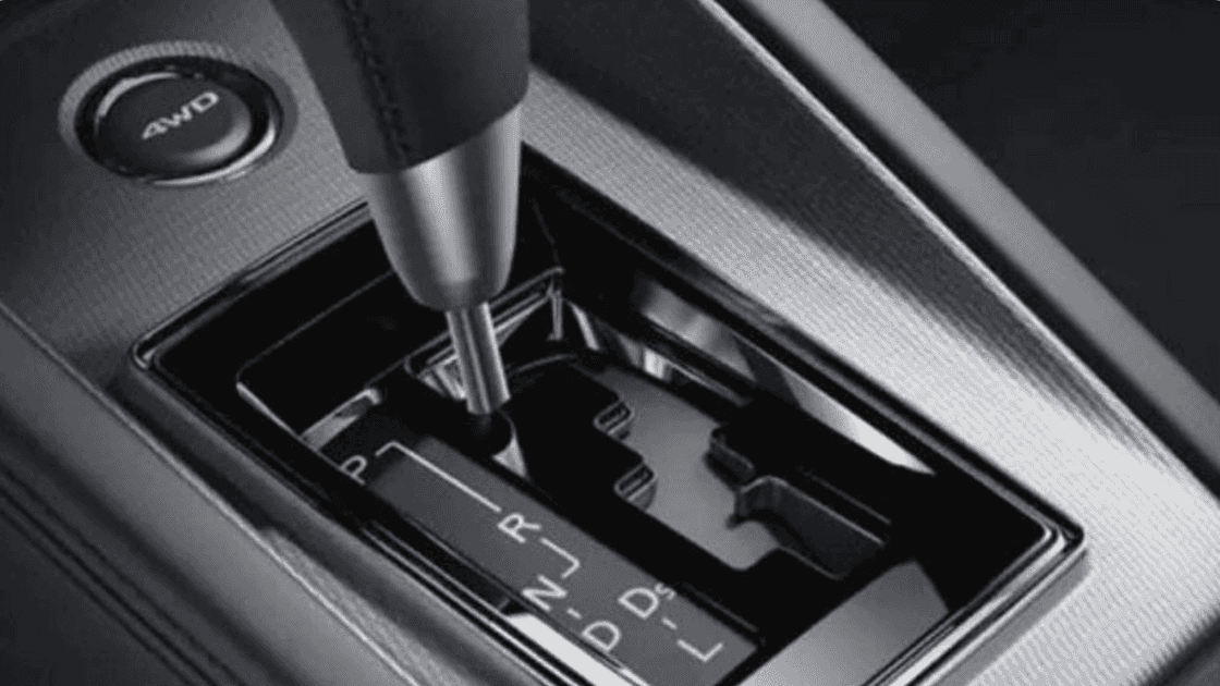 2024 MitsuClose-up of the 2025 Mitsubishi Outlander PHEV's front console, including the gear shifter and media controls.bishi Outlander Sport trunk with two leather duffle bags and spacious rear seating area.