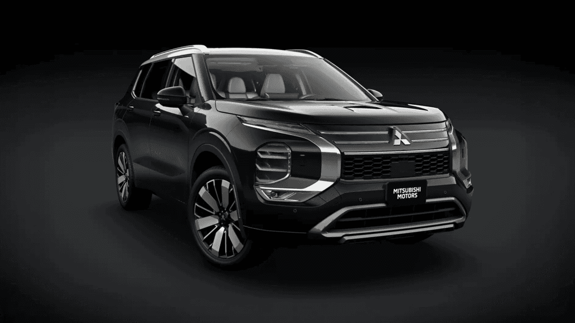 2024 Mitsubishi Outlander front three quarter exterior in black studio setting highlighting grille, LED lighting, and alloy wheels
