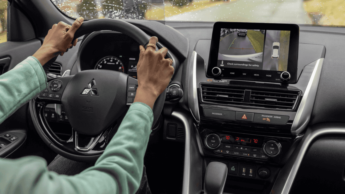 2025 Mitsubishi Eclipse Cross driver cockpit showing digital display, rearview camera screen, climate controls, and steering wheel