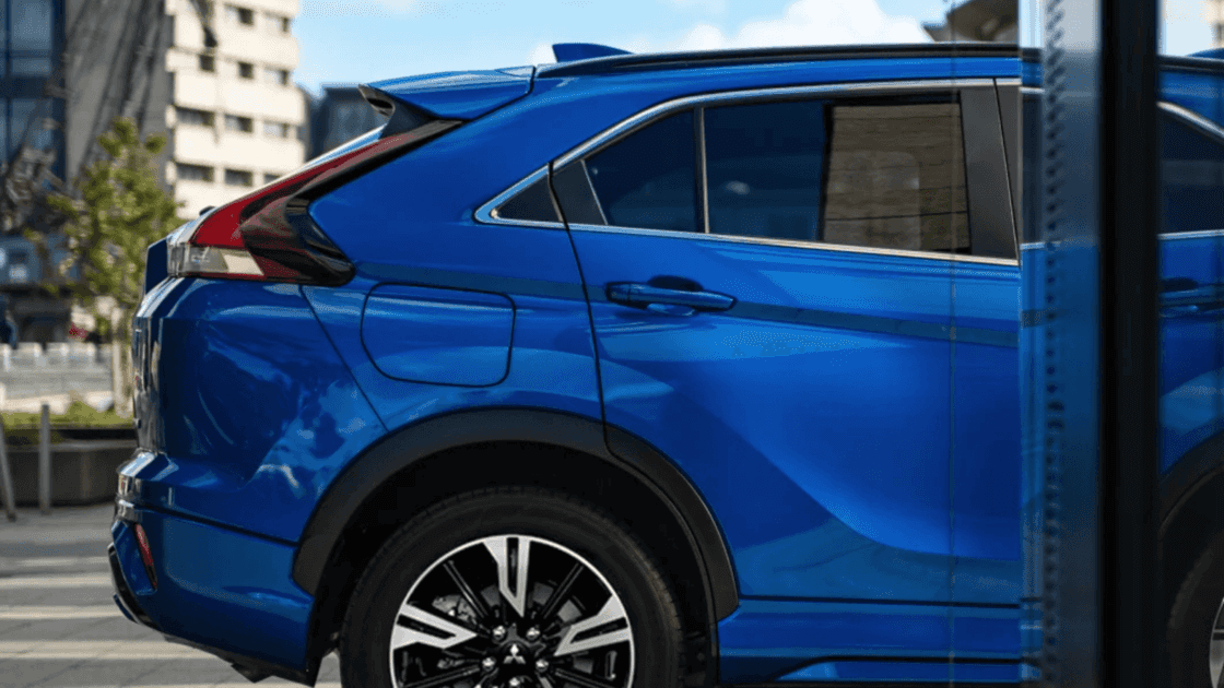 2025 Mitsubishi Eclipse Cross rear side exterior in blue highlighting alloy wheels, sculpted body lines, and rear quarter design