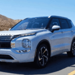 2025 Mitsubishi Outlander PHEV silver SUV driving on desert highway in daylight