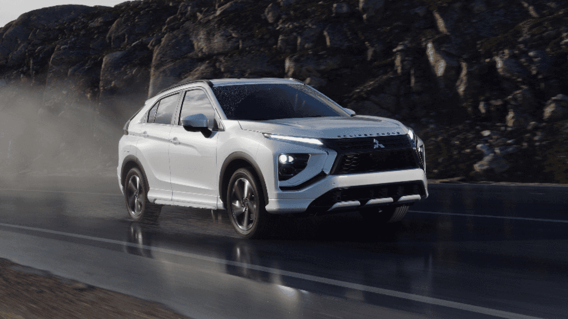 2026 Mitsubishi Eclipse Cross front three-quarter view driving on wet road in white