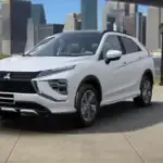 2026 Mitsubishi Eclipse Cross front three quarter exterior in white showing LED lighting, bold grille, and compact SUV profile