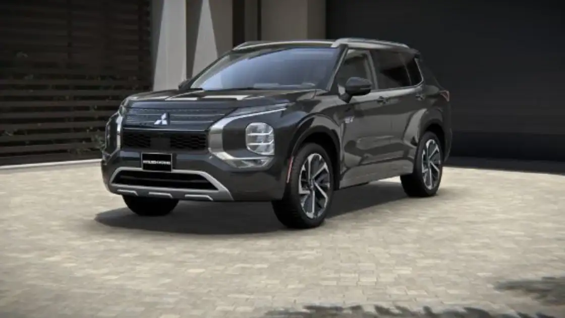 2026 Mitsubishi Outlander front three quarter exterior in dark gray showing LED lighting, bold grille, and midsize SUV profile