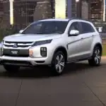 2026 Mitsubishi Outlander Sport front three quarter exterior in white showing LED lighting, signature grille, and compact SUV profile