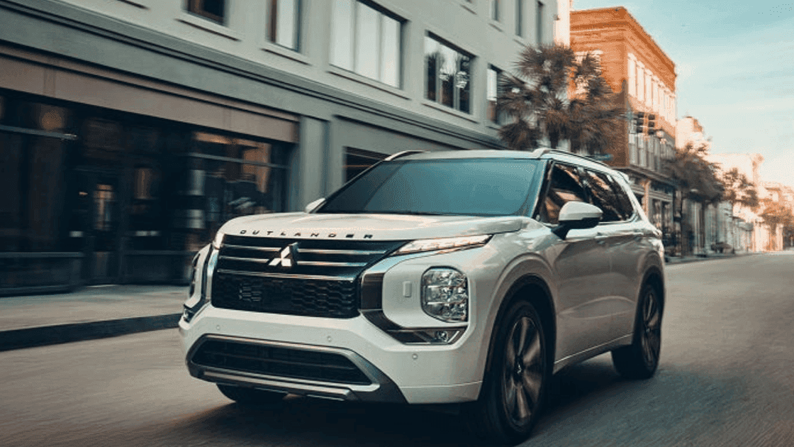 2026 Mitsubishi Outlander driving through a city street in front three quarter view