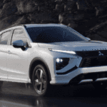 2026 Mitsubishi Eclipse Cross white SUV driving on wet road with LED lights and black grille
