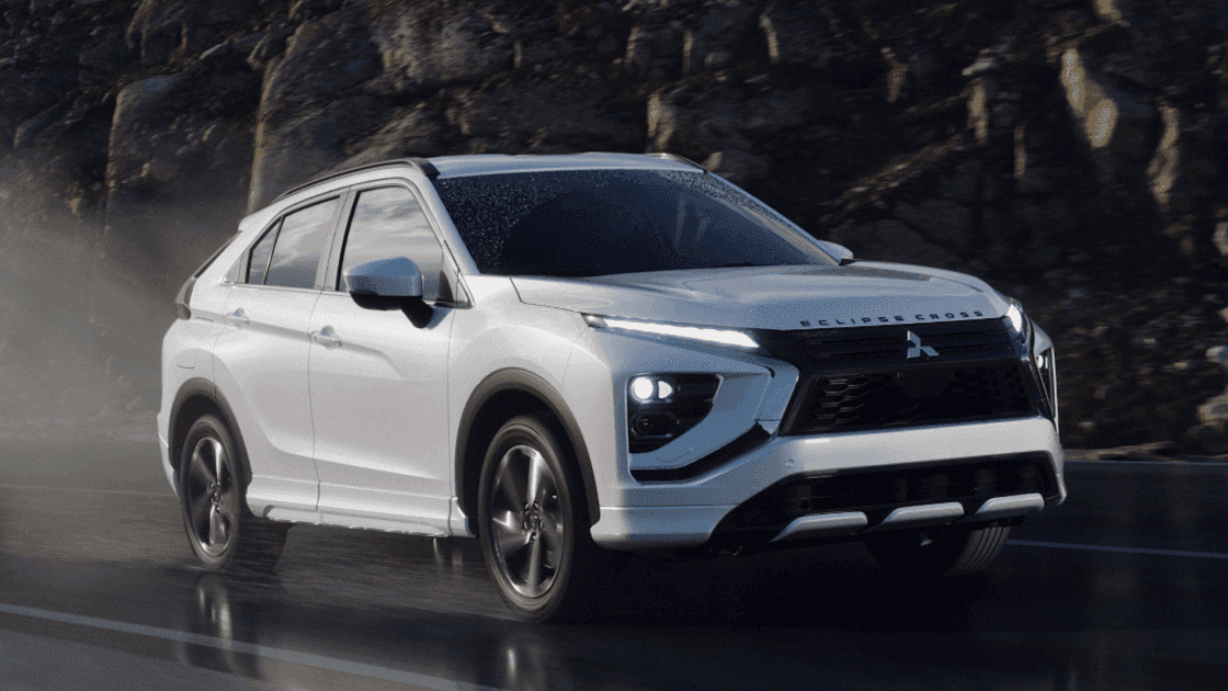 2026 Mitsubishi Eclipse Cross white SUV driving on wet road with LED lights and black grille