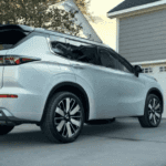 2026 Mitsubishi Outlander white SUV parked in driveway with rear styling and black roof trim