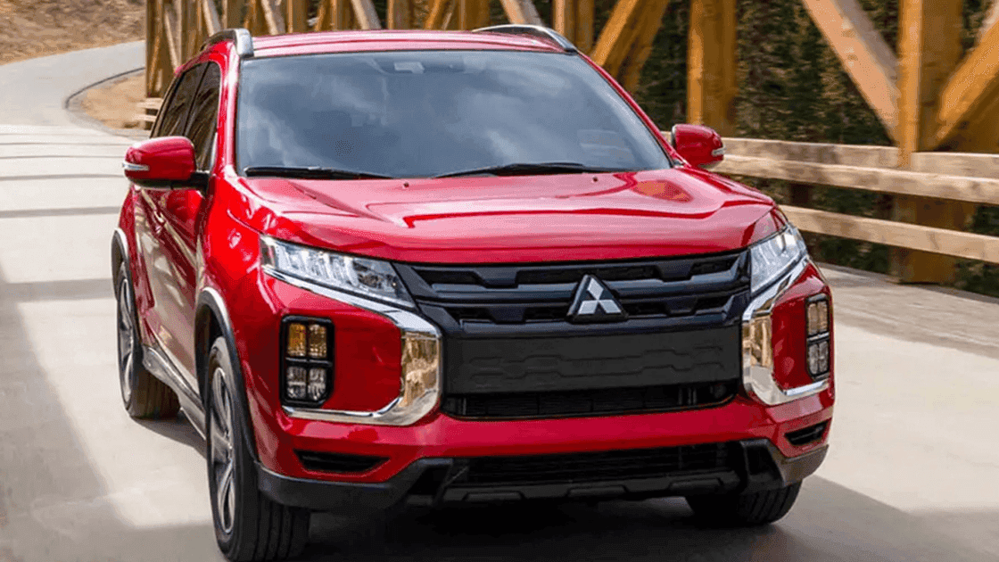 Front exterior view of red 2026 Mitsubishi Outlander Sport driving on a road