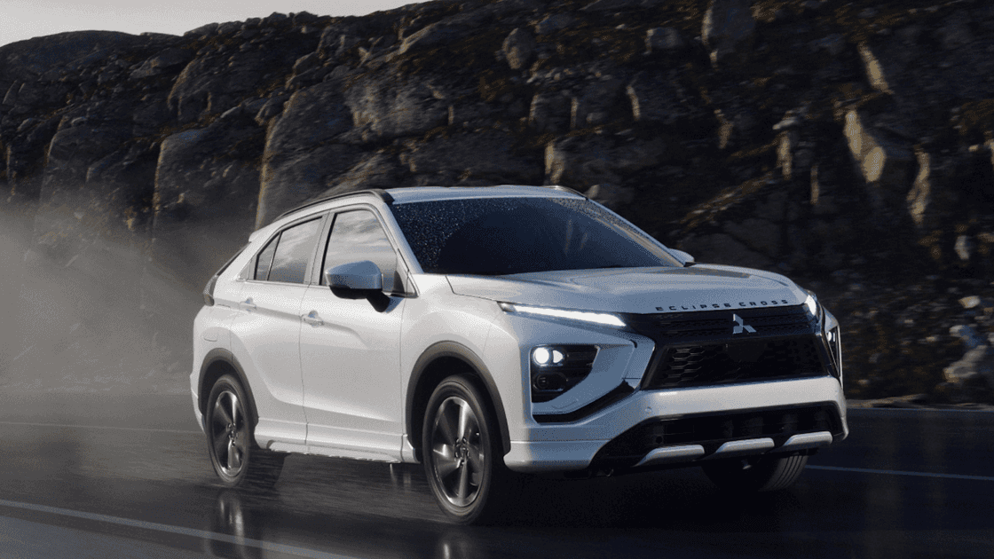 2026 Mitsubishi Eclipse Cross white SUV driving on wet road with LED lights and black grille