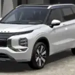 2026 Mitsubishi Outlander white SUV parked outside a modern home with roof rails and alloy wheels