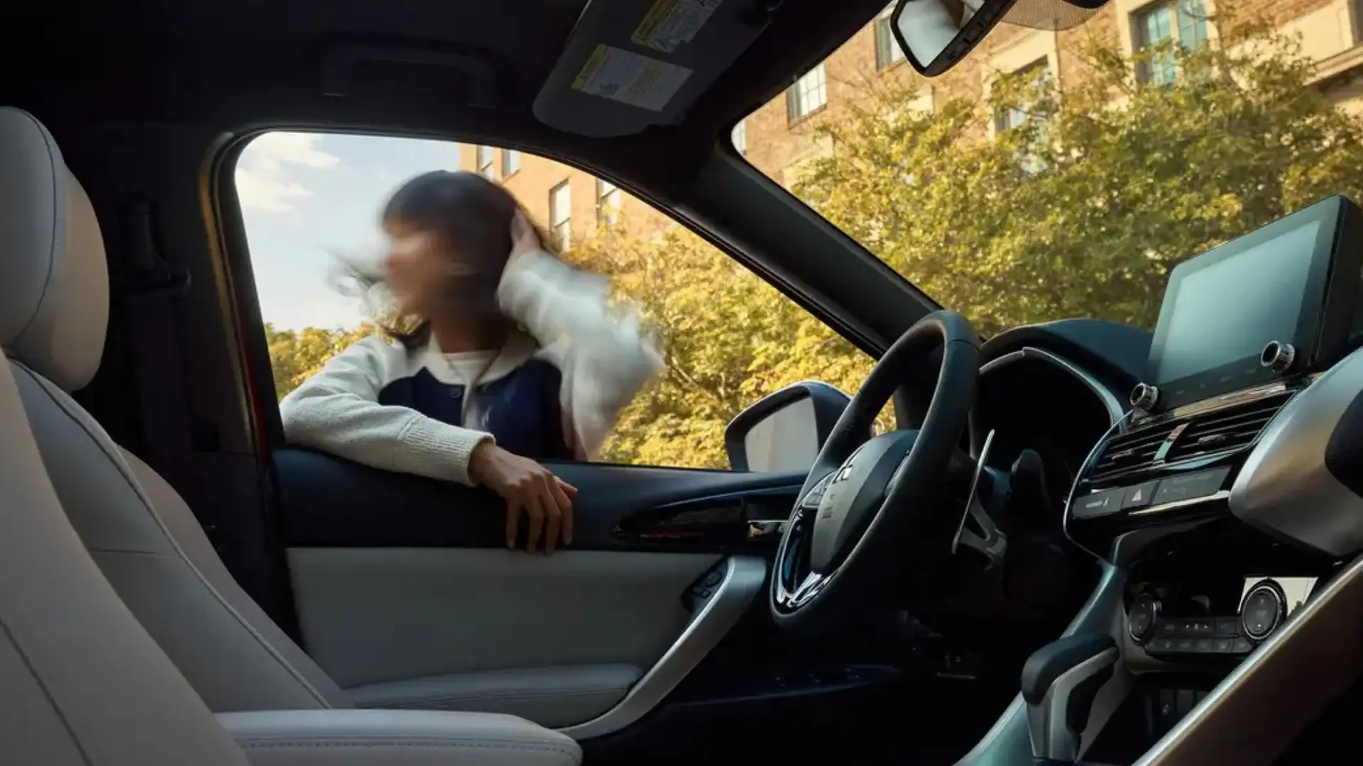 2026 Mitsubishi Eclipse Cross cabin with touchscreen, steering wheel and bright front seats in view.