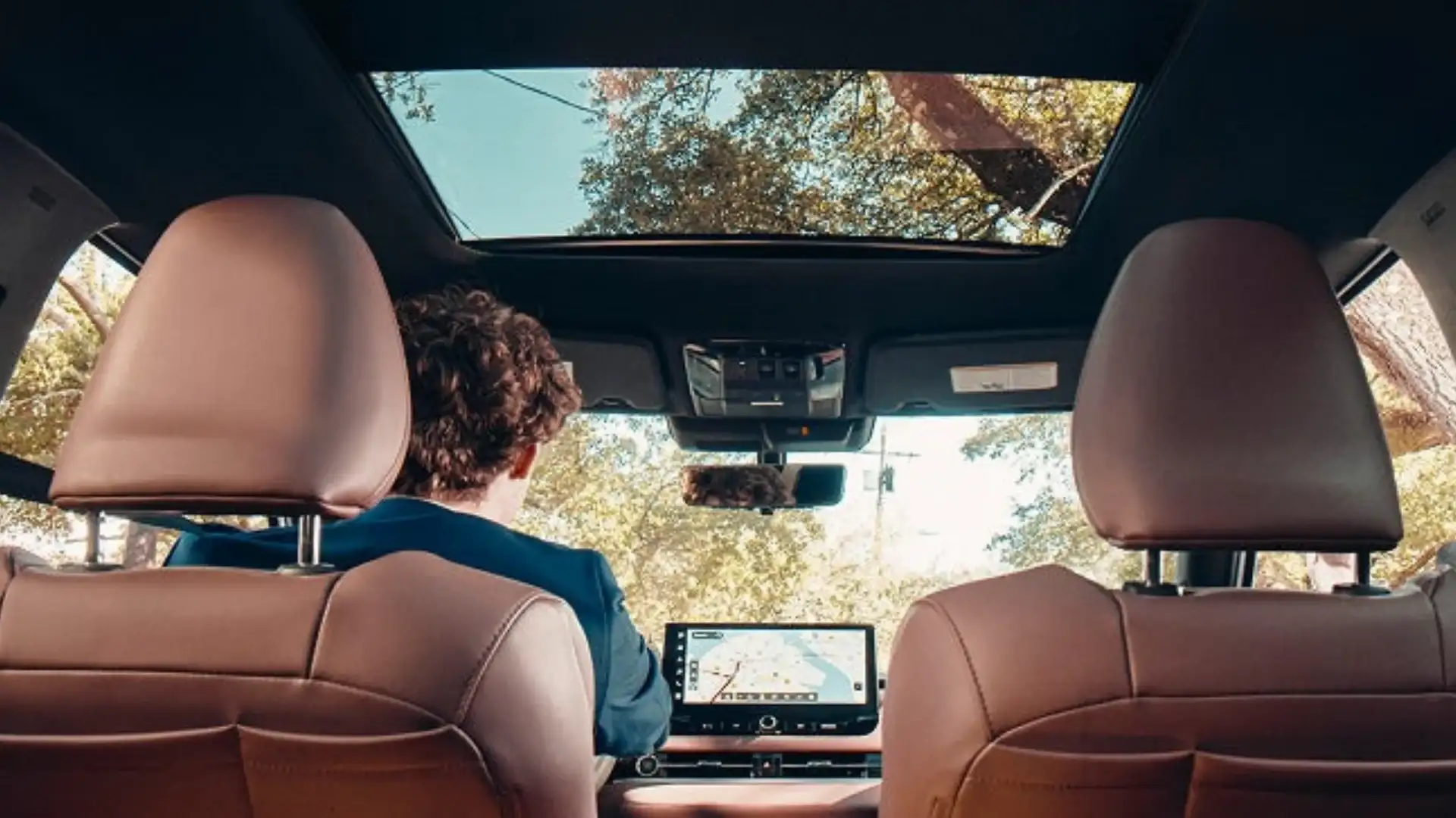 2026 Mitsubishi Outlander interior with brown seats, panoramic roof and central touchscreen display.
