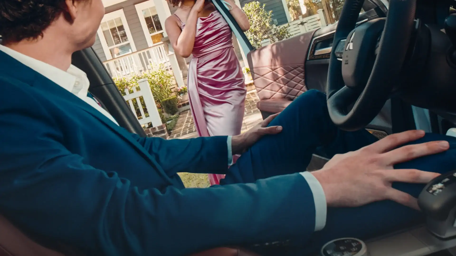 2026 Mitsubishi Outlander interior with driver seated while a woman stands beside the open front door.