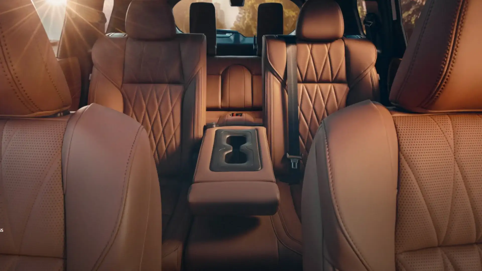 2026 Mitsubishi Outlander cabin with brown leather seating, second-row captain chairs, and center console.