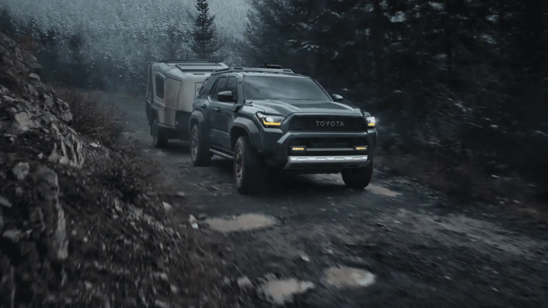 2025 Toyota 4Runner i-FORCE MAX towing a trailer on a rugged road near Hagerstown, MD, demonstrating off-road capability and towing strength.
