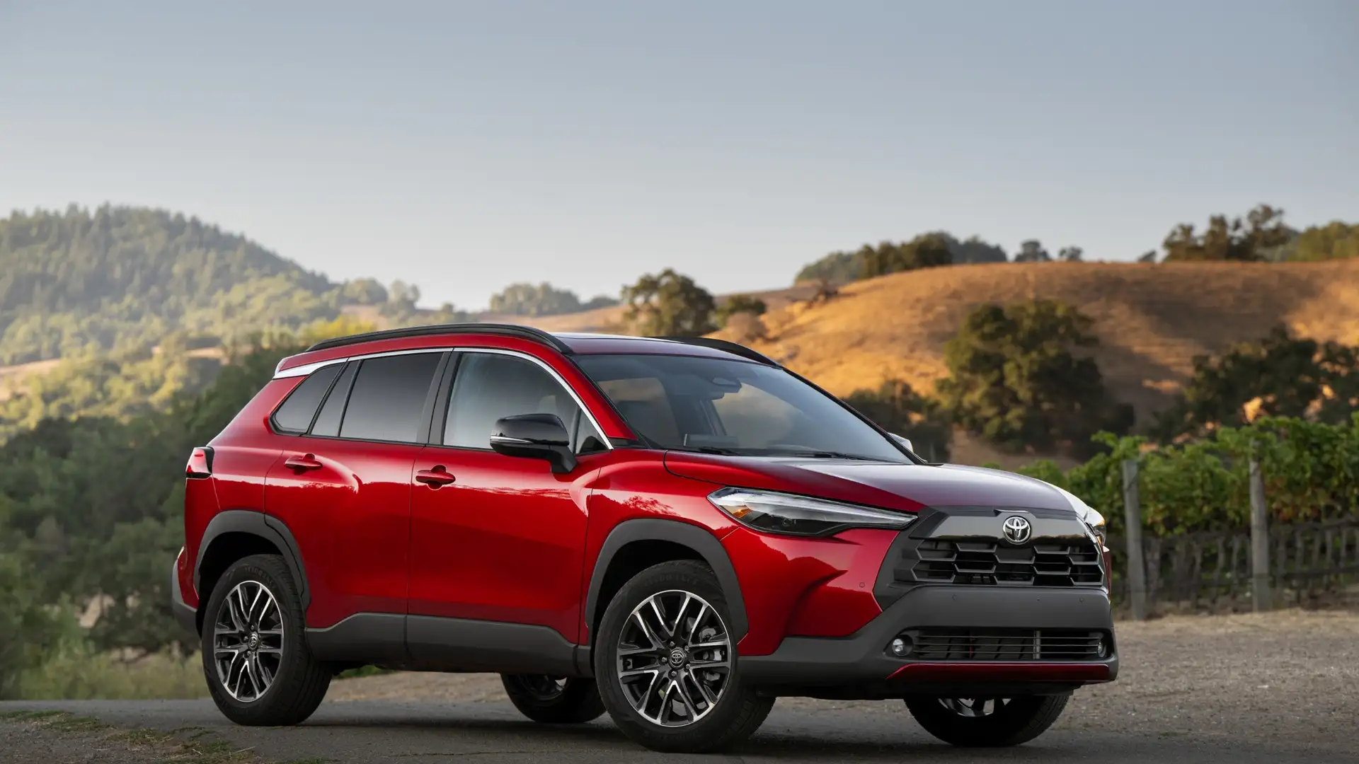 2025 Toyota Corolla Cross exterior view showing compact SUV profile, black wheels, and contemporary front-end design.